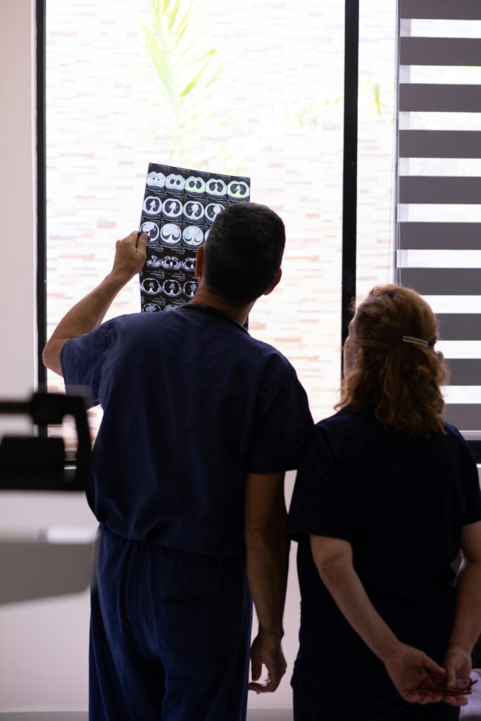 pexels-photo-8460379-8460379 Medical professionals examining an X-ray for diagnosis in a hospital environment.