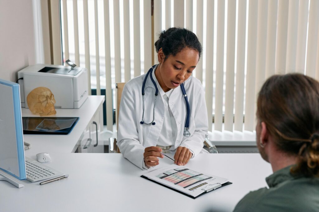 pexels-photo-7578803-7578803 A doctor consulting with a patient in an office, discussing a medical chart.